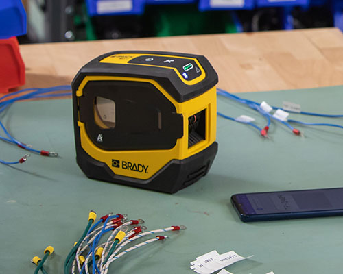 De M511-printer met gelabelde draden en een mobiele telefoon.