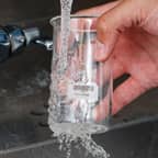 Een glazen erlenmeyer met een oplosbaar Brady-label wordt gereinigd en het label wordt verwijderd.