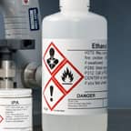 Een container ethanol met een GHS-veiligheidslabel dat de inhoud identificeert.