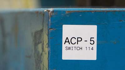 Een wit label op een apparaat met tekst 