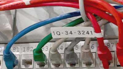 Een Brady-label in de vorm van een P-vlaggetje gemaakt van mat polypropyleen aangebracht op een Cat-5e-ethernetkabel.