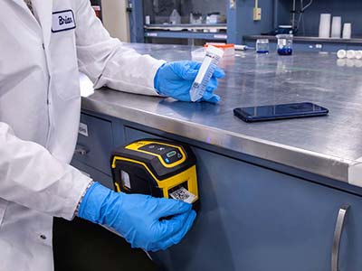 Een M211 labelprinter wordt handig bevestigd aan een werkstation in een laboratorium.