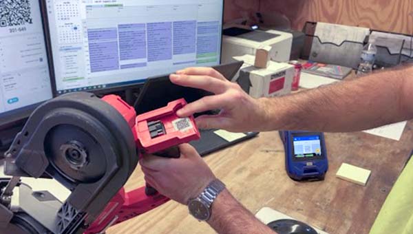 Een persoon wijst naar een label op een gereedschap.