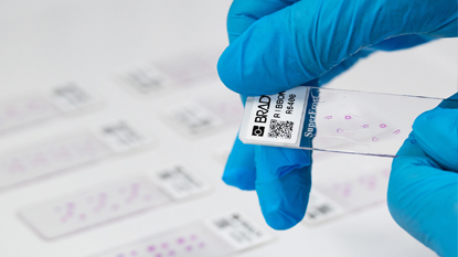 Een persoon die het label op een glazen tester van een apotheek gebruikt.